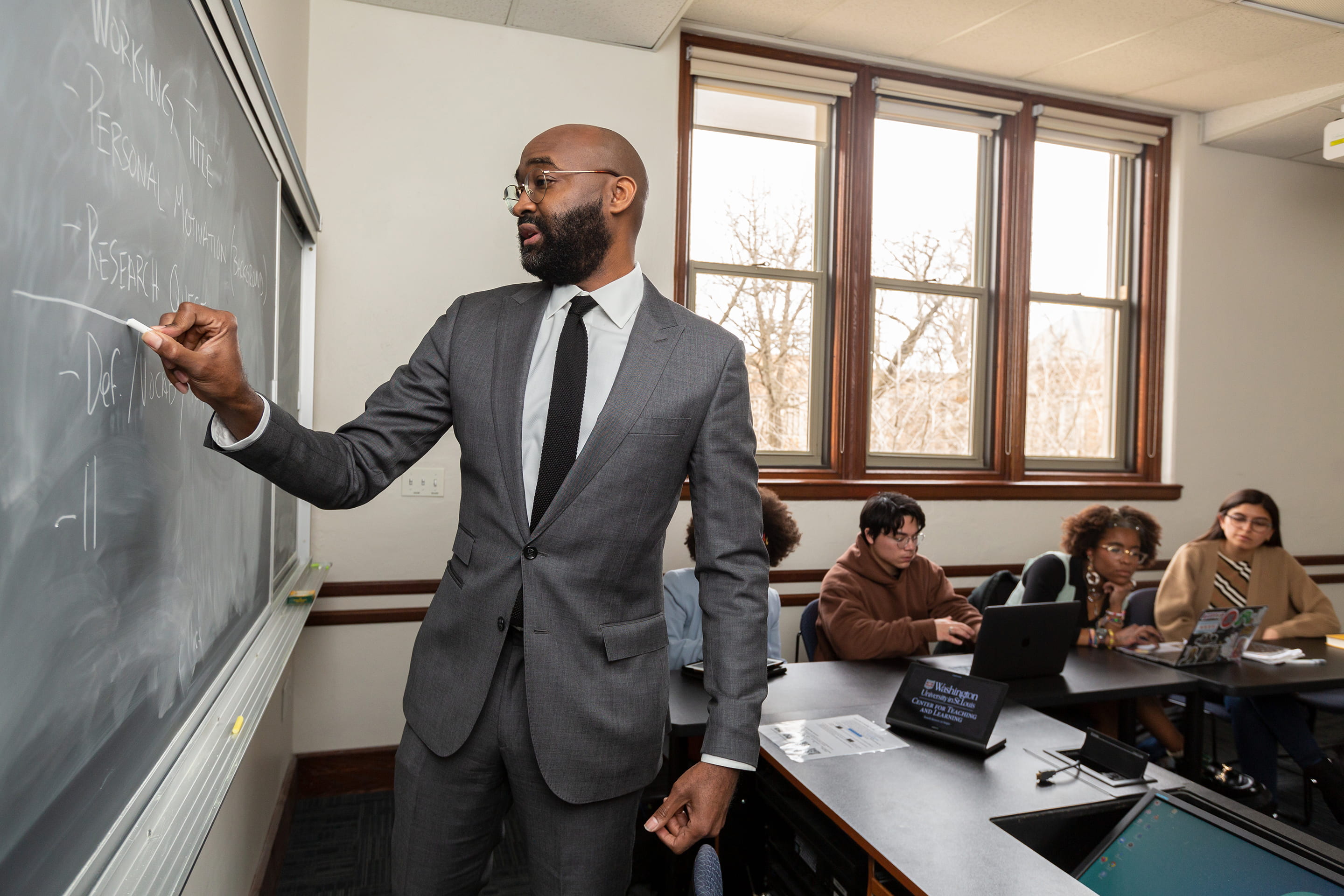 Jonathan Fenderson, Associate Professor in African & African American Studies, writes on the chalkboard as students take notes